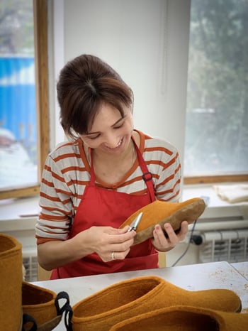 woman creating a shoe with a razor tool