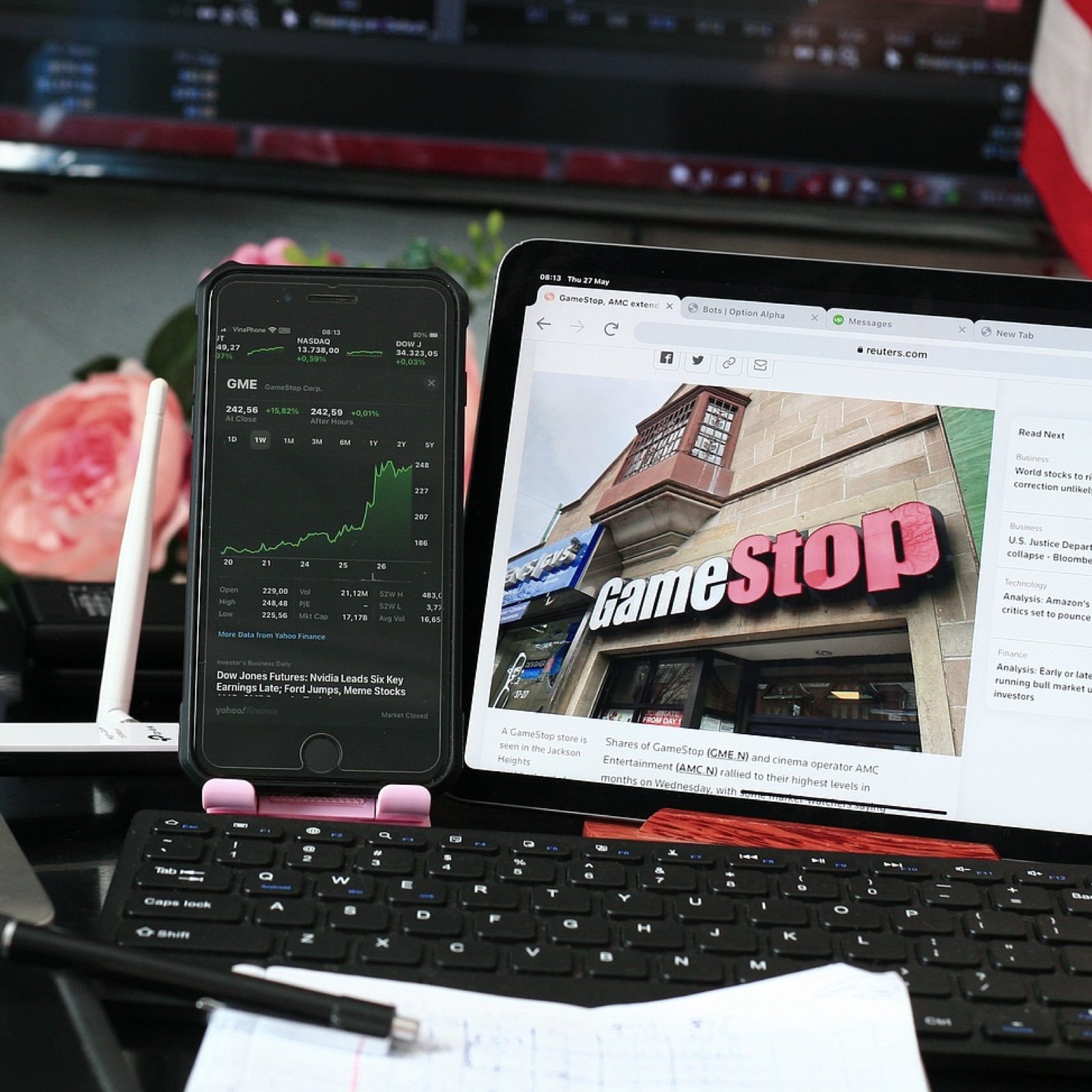 Photo of GameStop on laptop and phone showing stock trends