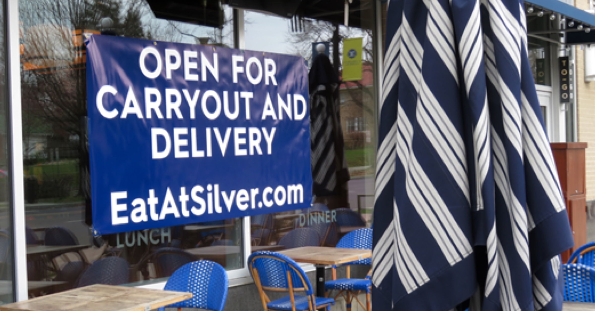 Picture of restaurants showing with sign showing that they are open for business with carryout and delivery.